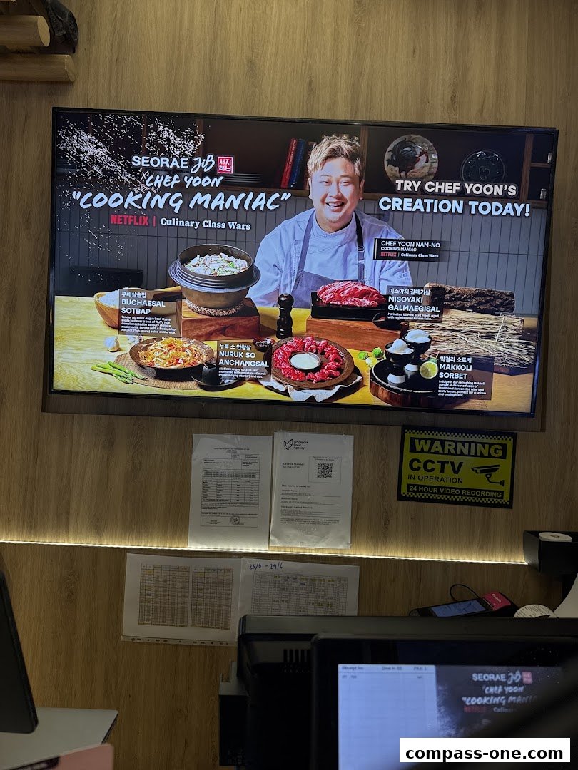 A screen displays Korean dishes and Chef Yoon, promoting a 'Cooking Maniac' event.