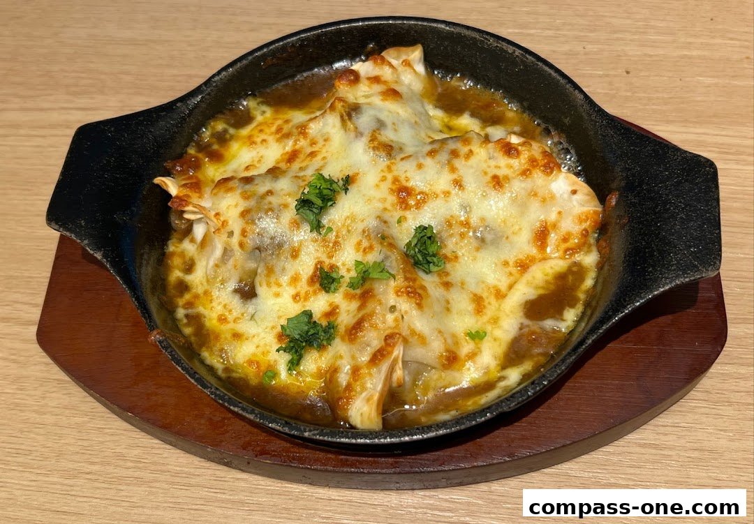 A close-up of a sizzling dish topped with melted cheese and parsley.