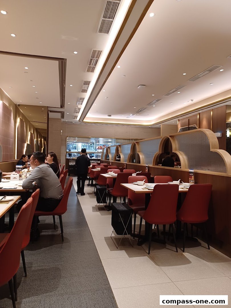 Interior view of a modern restaurant with red chairs and white tables.
