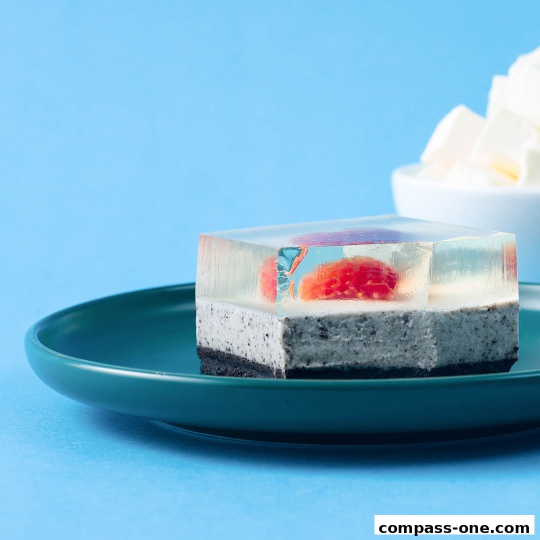 A square jelly dessert with fruit and cookie crumble layers on a teal plate.