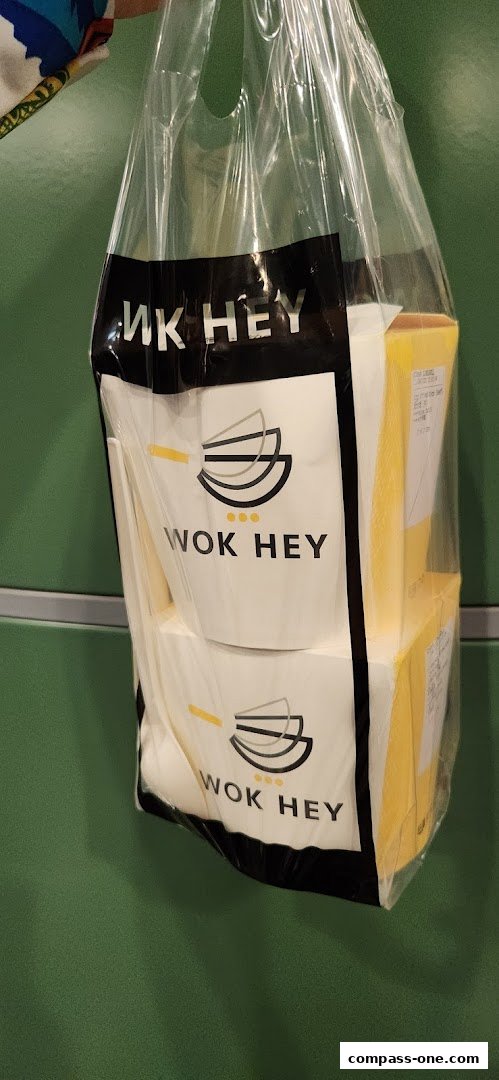 A plastic bag from Wok Hey containing multiple food containers.