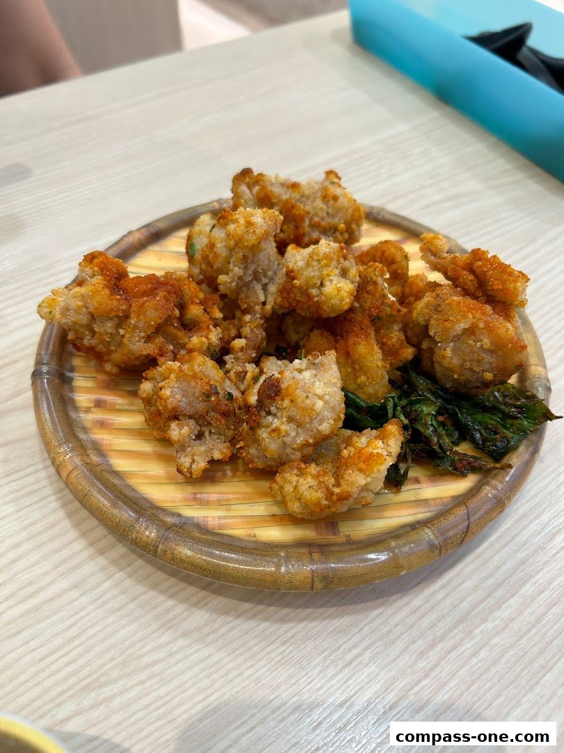 A plate of crispy fried chicken bites seasoned with spices, served with fried greens.