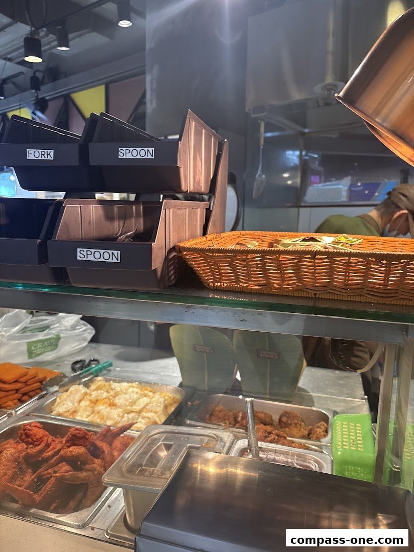 A display of various food items, including fried chicken and rice, at a food stall.