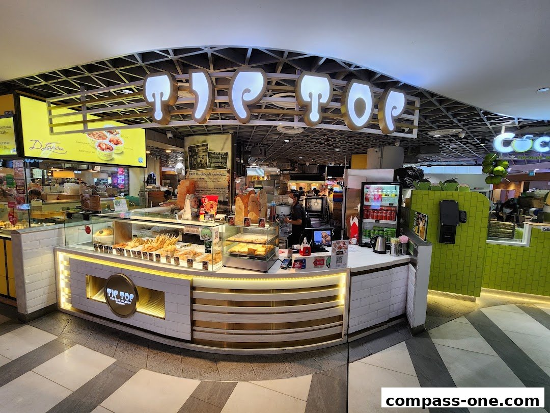 The Tip Top Curry Puff shop front with a display of various snacks and drinks.