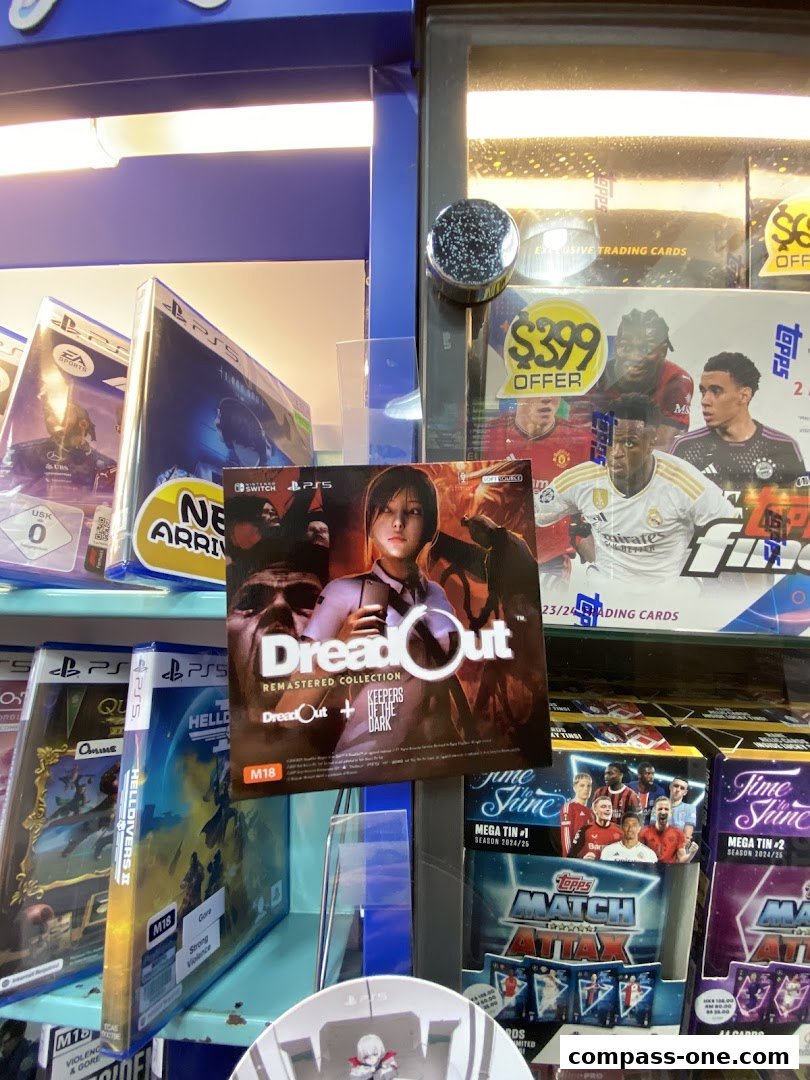 A display of video games and trading card packs, including PlayStation titles and football trading cards.