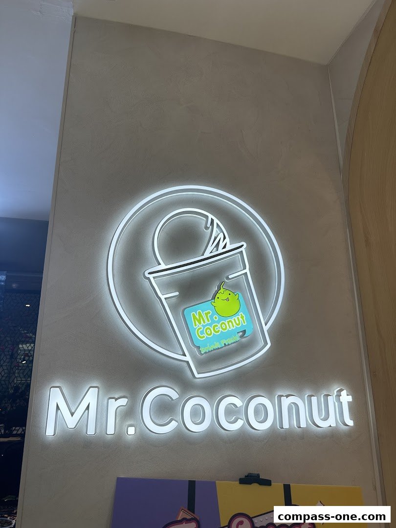 A brightly lit sign for Mr. Coconut, featuring the brand logo and name.