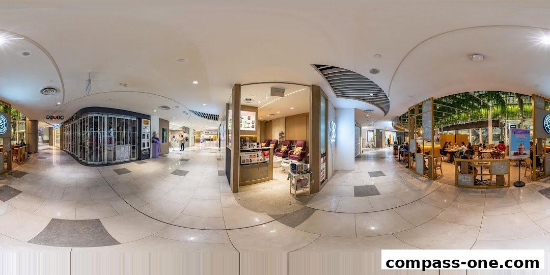 Interior view of a shopping mall corridor with shops and seating areas.