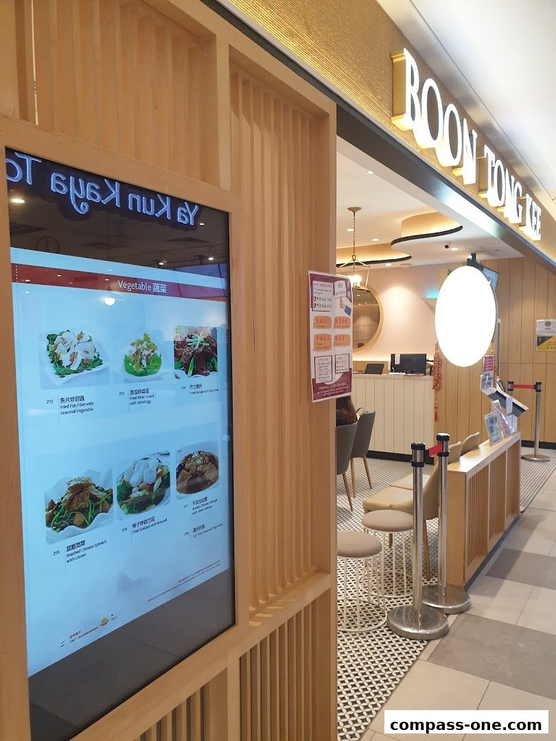 The exterior of Boon Tong Kee restaurant with a digital menu displaying food items.