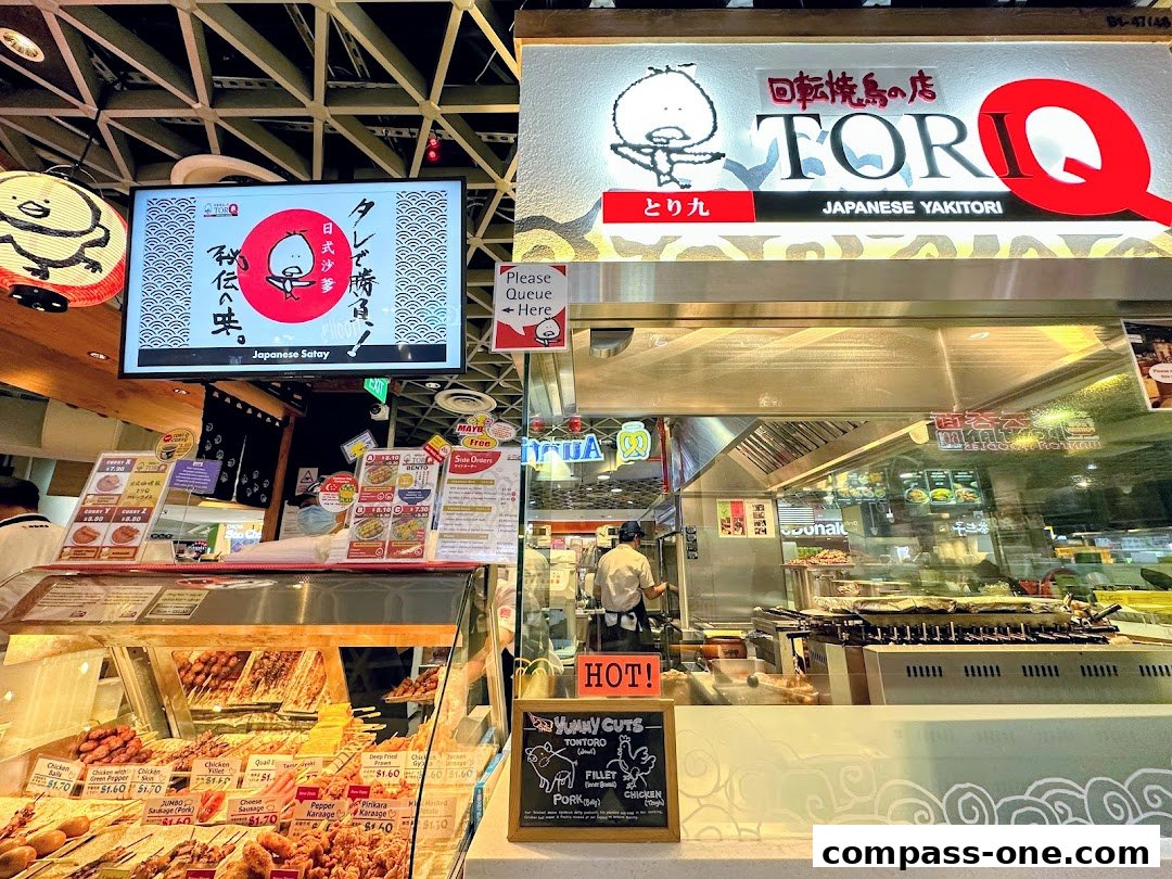 A vibrant display of Japanese yakitori skewers at Tori-Q, with a prominent sign and menu boards.