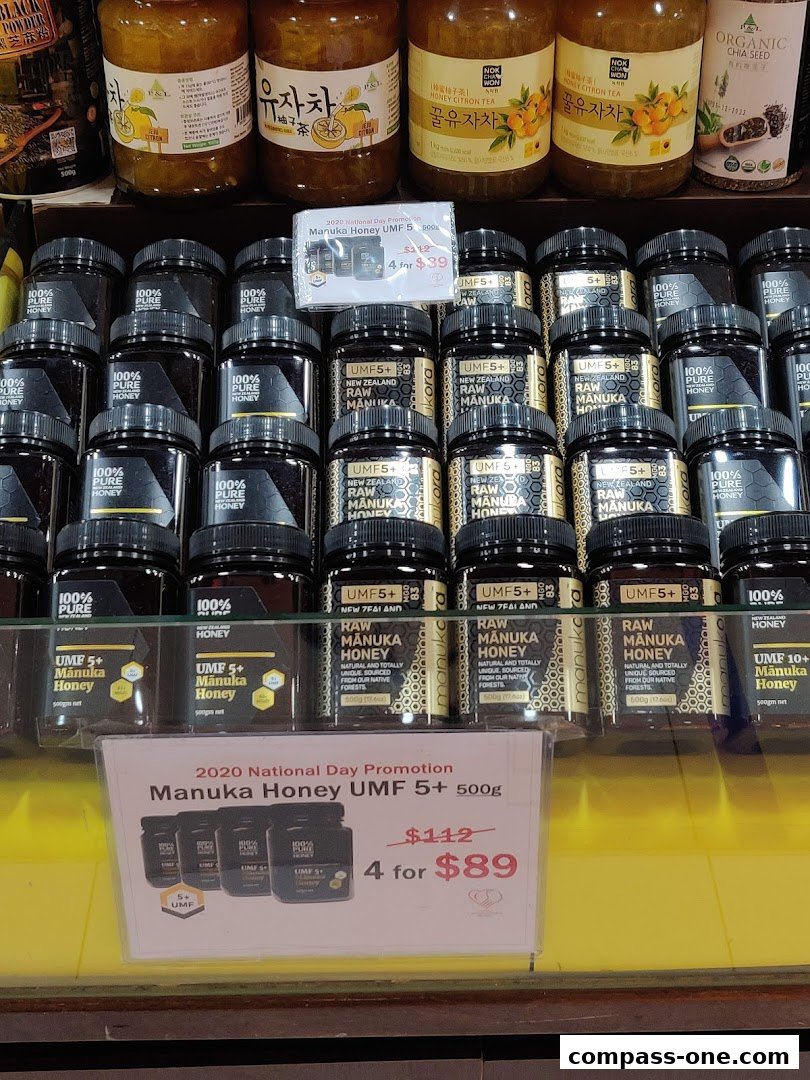 A display of Manuka honey jars and other health products on shelves, with a promotion sign.