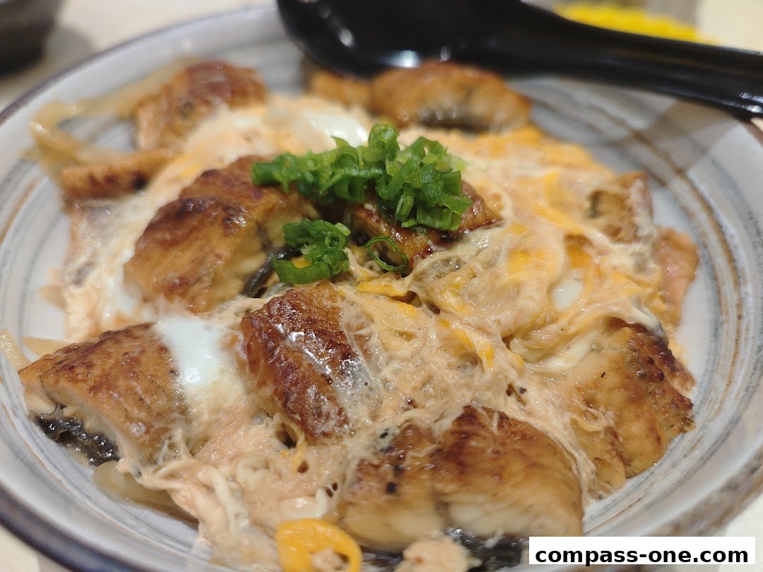 A close-up of a delicious Unagi Donburi dish with grilled eel and scrambled eggs.