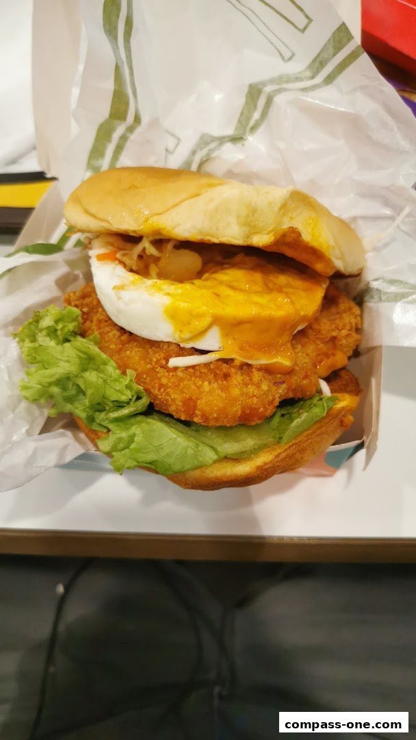 A close-up shot of a delicious-looking chicken burger with lettuce and sauce.