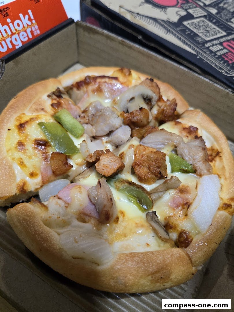 A close-up of a delicious Pizza Hut pizza with chicken, mushrooms, and green peppers.