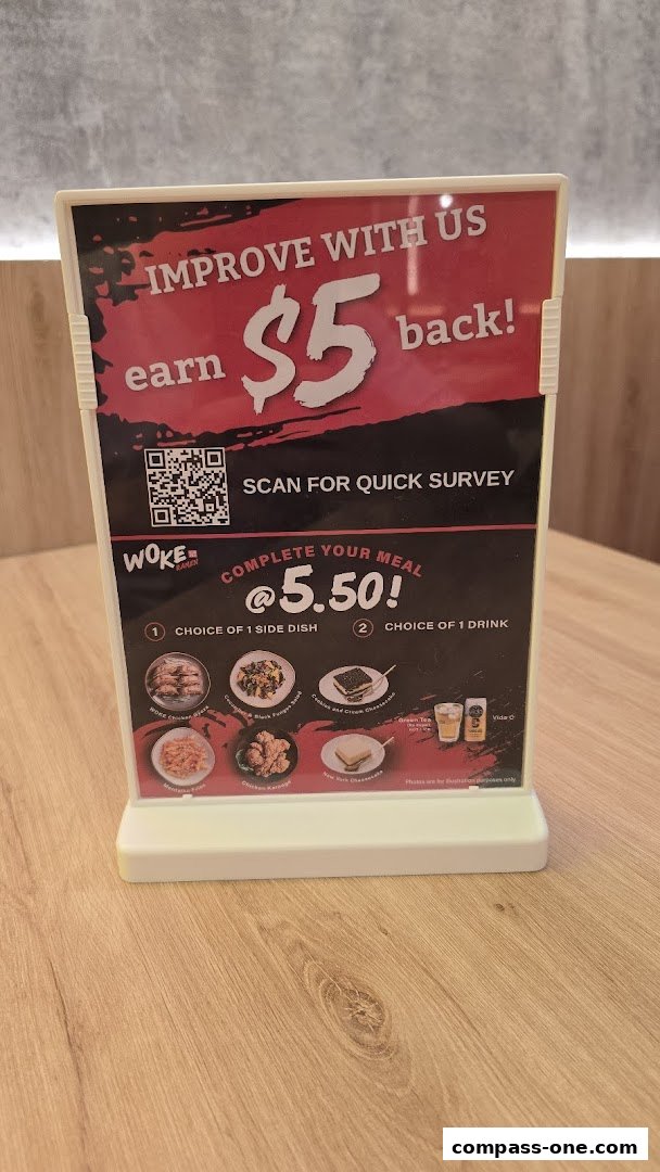 A sign promoting a meal deal and a survey at WOKE Ramen.