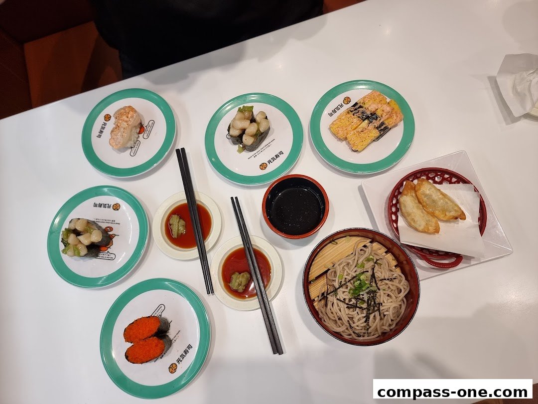 A table laden with various sushi dishes, soba noodles, and gyoza, ready to be enjoyed.
