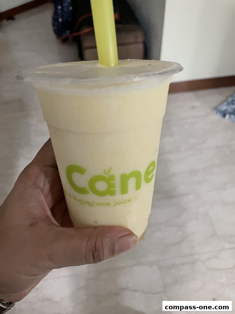 A hand holds a refreshing sugarcane juice drink from CocoCane.