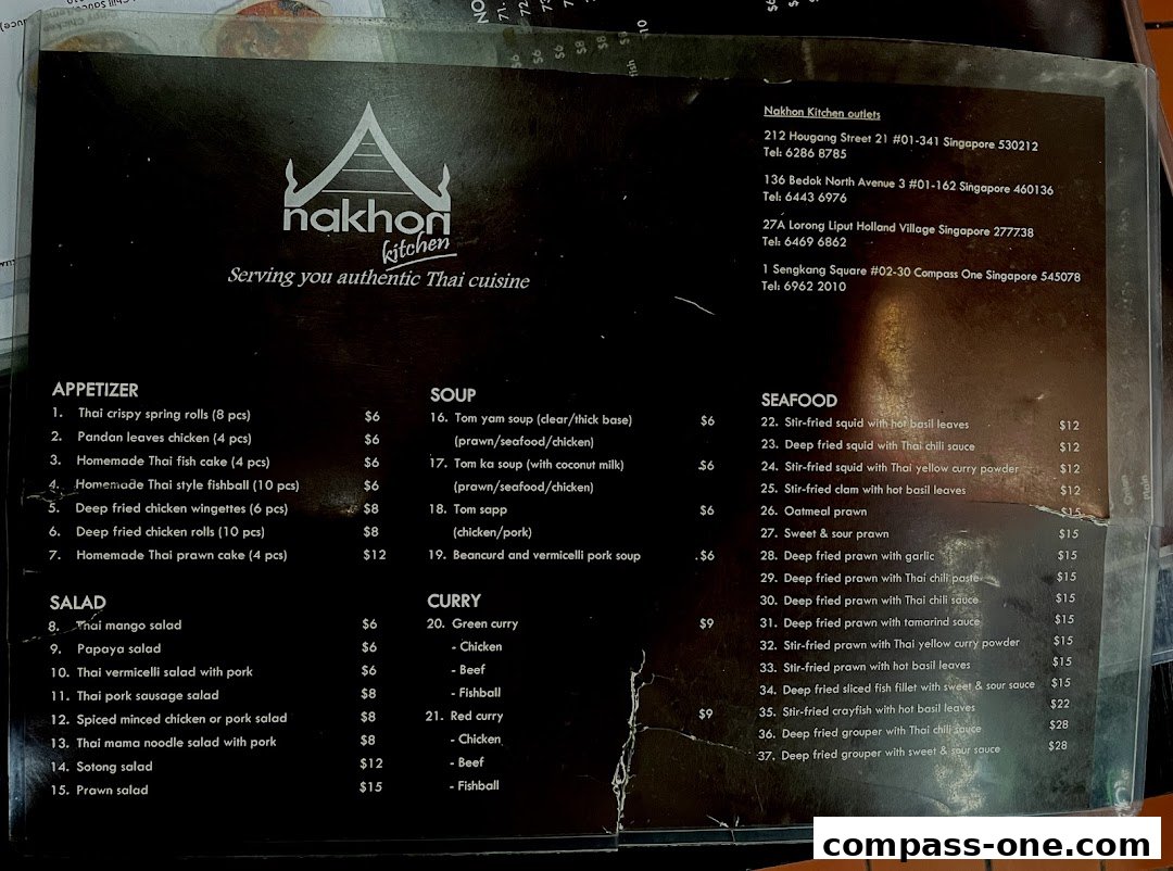 A menu from Nakhon Kitchen showcasing appetizers, salads, soups, curries, and seafood dishes with prices.