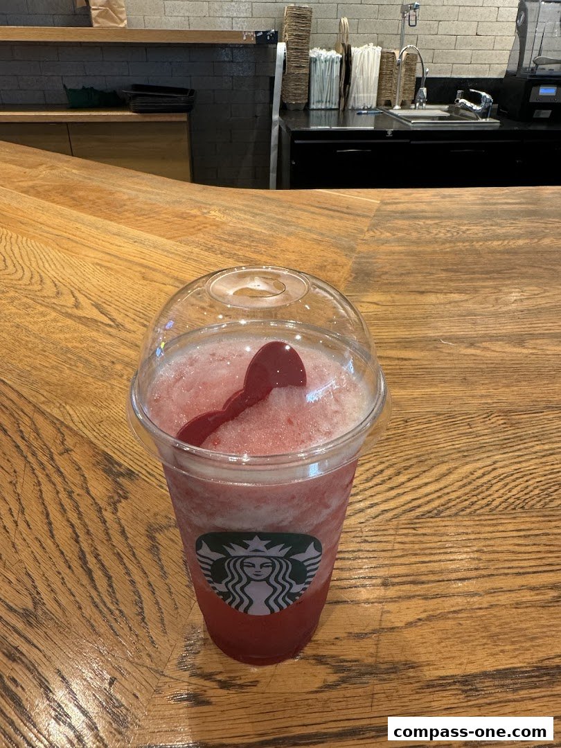 A refreshing strawberry-flavored blended drink with the Starbucks logo on a wooden counter.