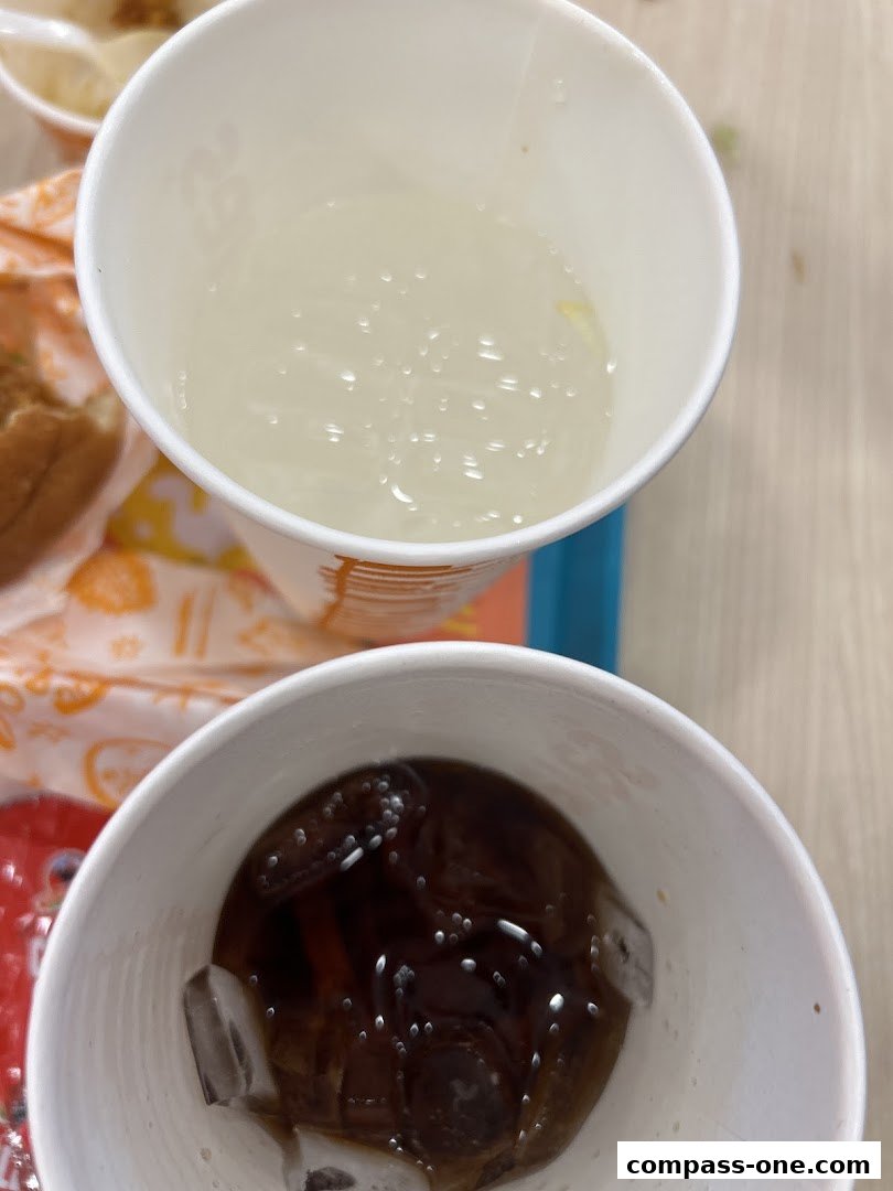 Two cups of drinks, one with ice and cola, the other with a clear beverage.