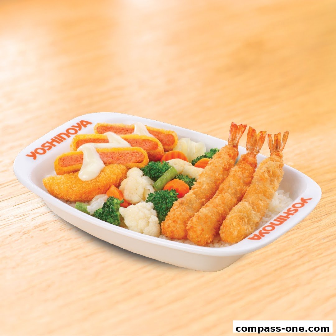 A Yoshinoya meal featuring crispy fried shrimp, chicken pieces, and mixed vegetables on rice.