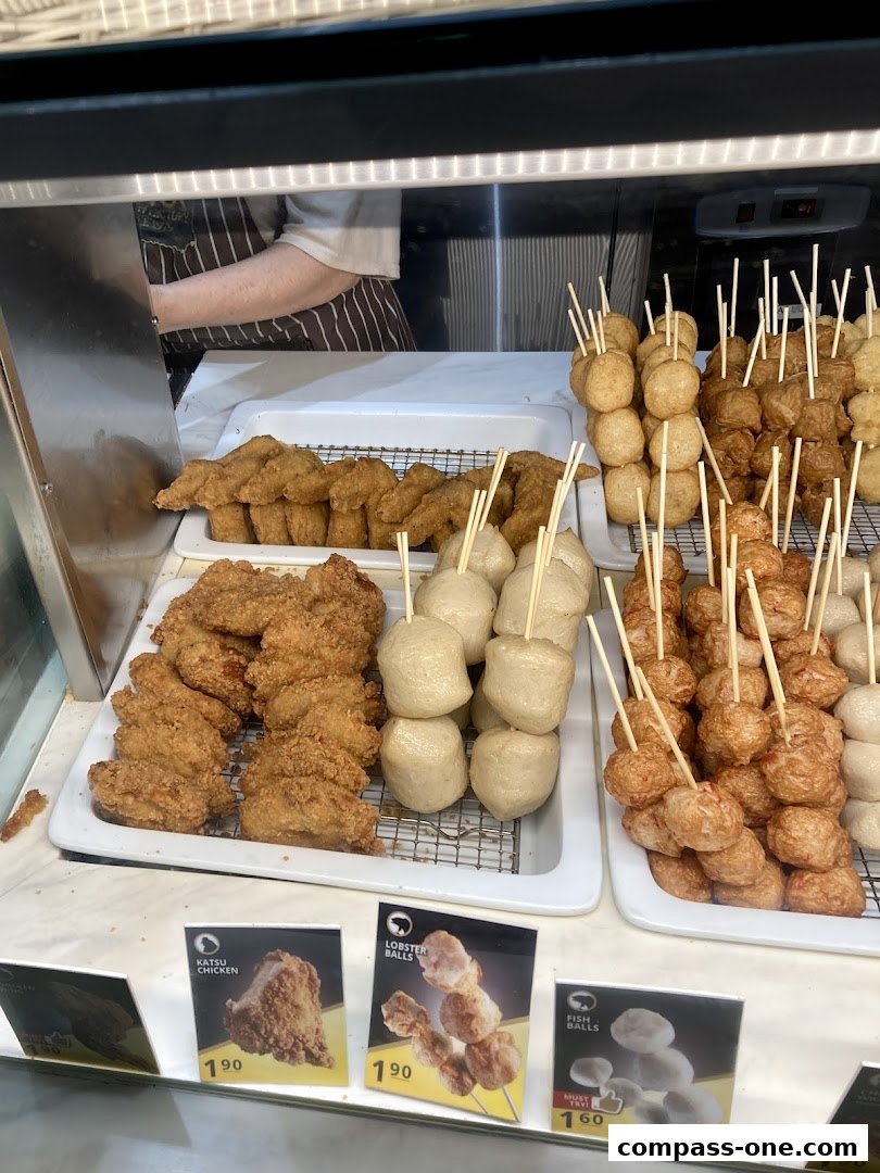 A display of various fried snacks on skewers, including chicken and meatballs.