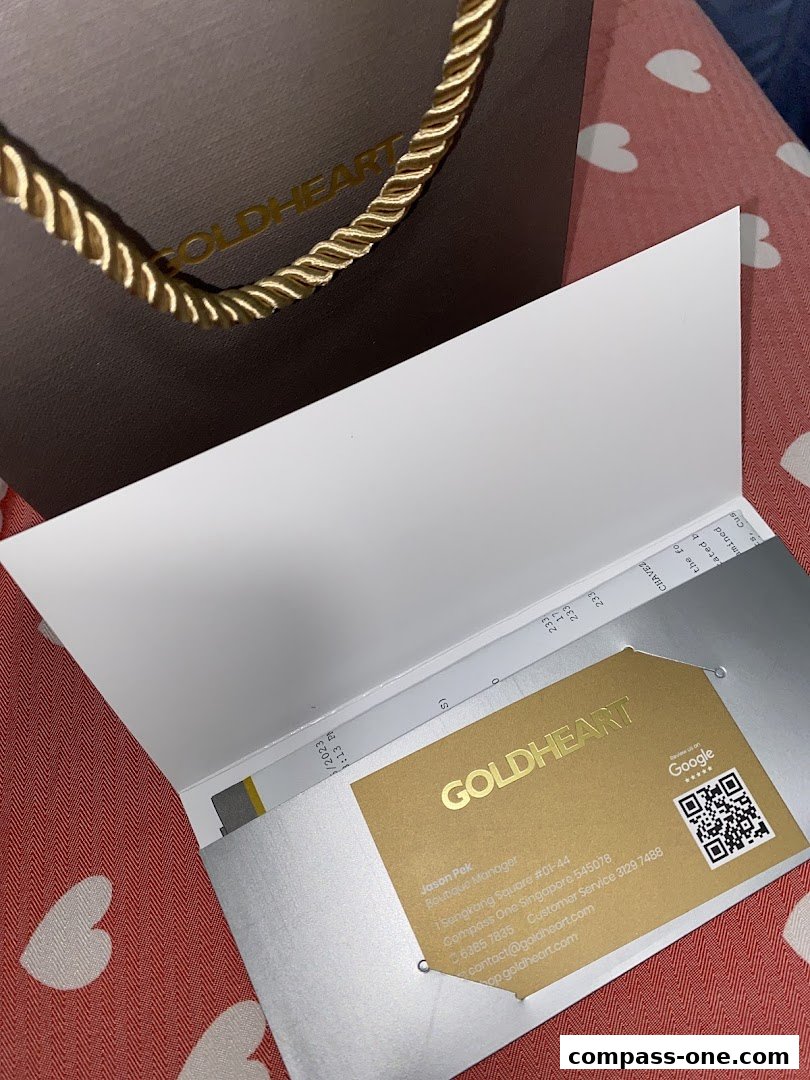 A Goldheart branded shopping bag and a business card with contact details.