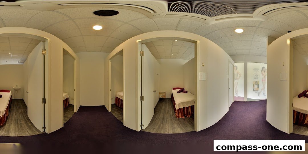 Interior view of a spa with multiple treatment rooms, each featuring a massage bed.