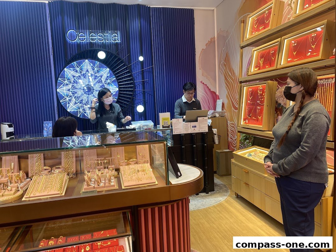A jewelry store interior with customers and staff interacting at the counter and displays.