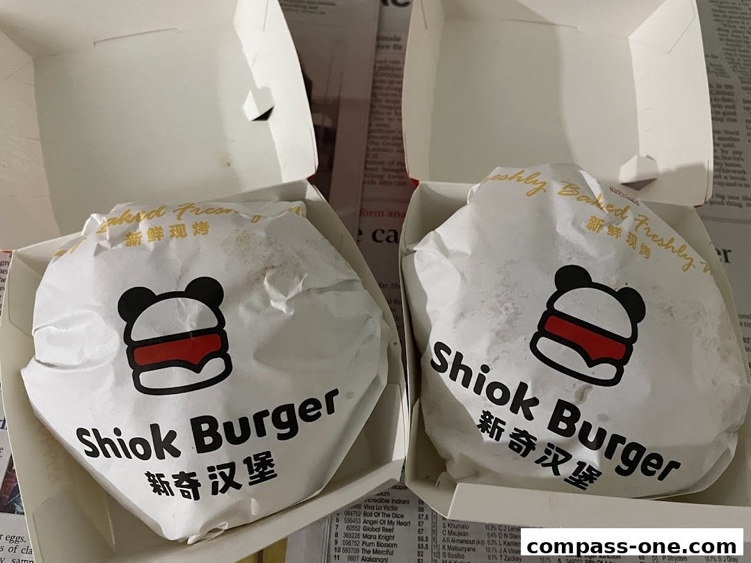Two Shiok Burger boxes are open, revealing burgers wrapped in branded paper.