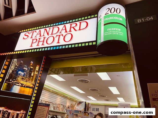 The entrance of a photography shop with a large 'STANDARD PHOTO' sign and film roll display.
