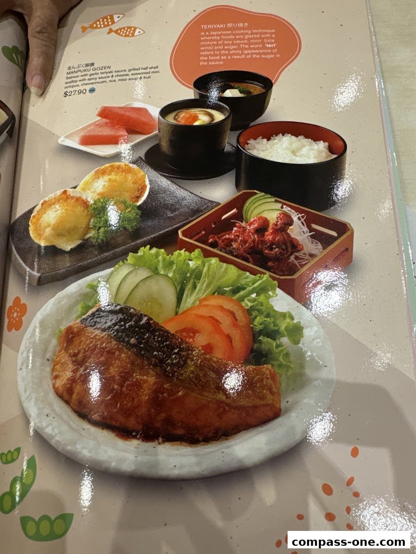 A close-up of a Japanese menu featuring a salmon teriyaki dish and a Manpuku Gozen set.