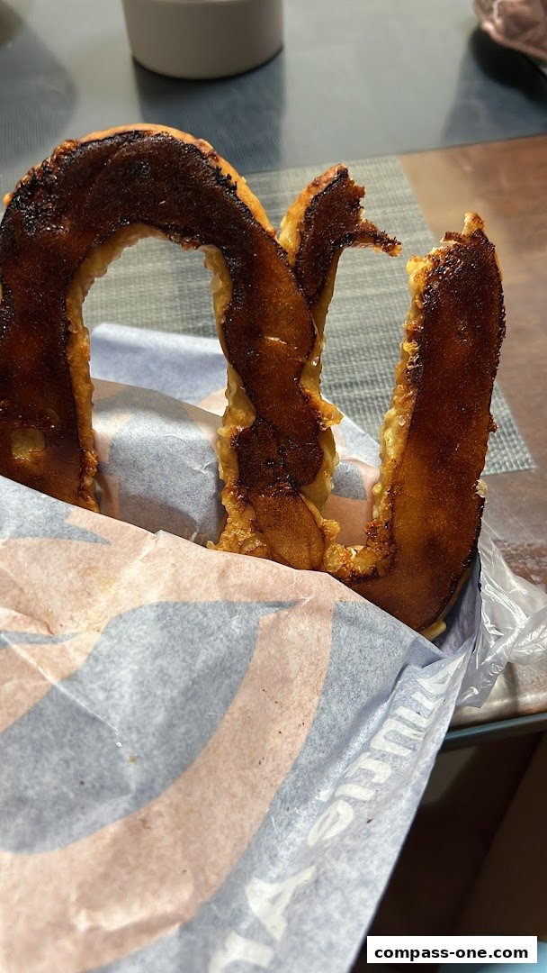 A close-up of a burnt pretzel from Auntie Anne's, wrapped in branded paper.