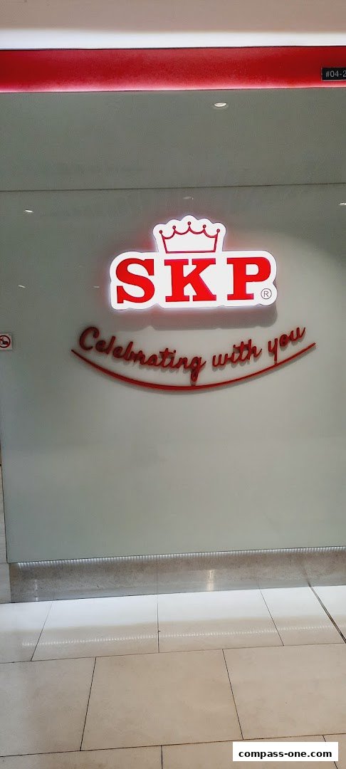 The SKP logo with the tagline 'Celebrating with you' is displayed on a glass storefront.