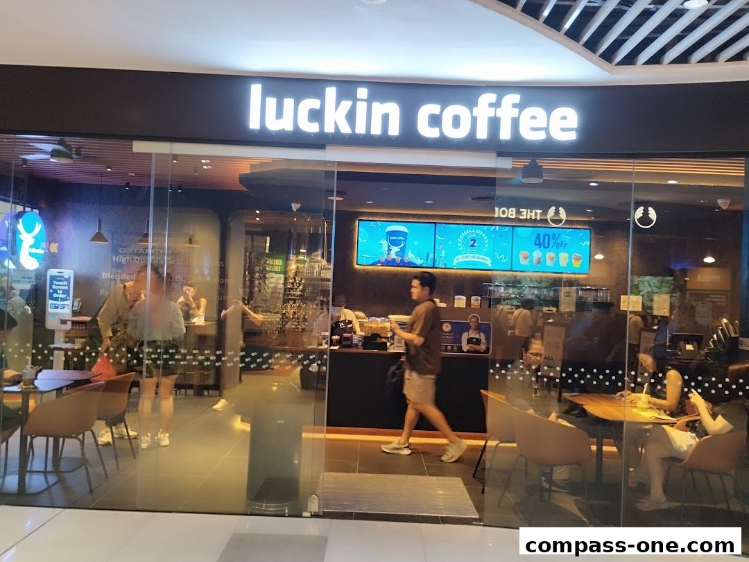 The exterior of a Luckin Coffee shop with customers inside and a prominent sign.