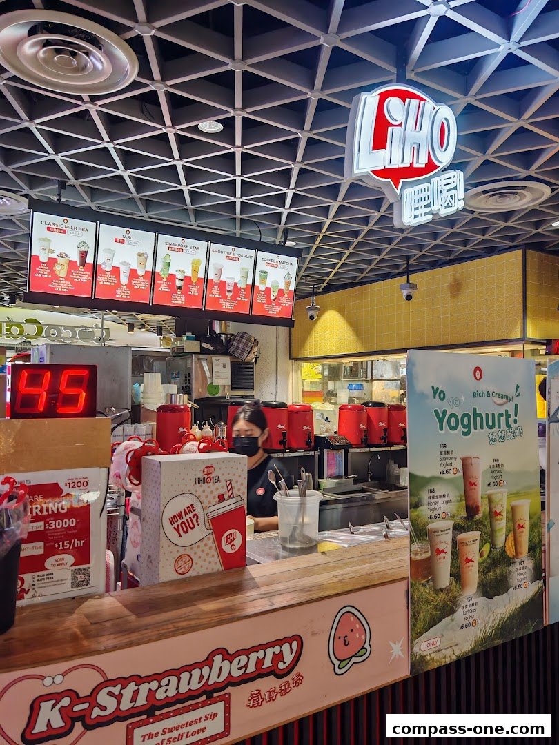 A LiHo Tea shop counter with a menu board, staff, and promotional displays.
