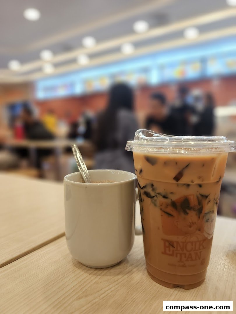 Two drinks, one in a mug and one in a plastic cup, sit on a wooden table.