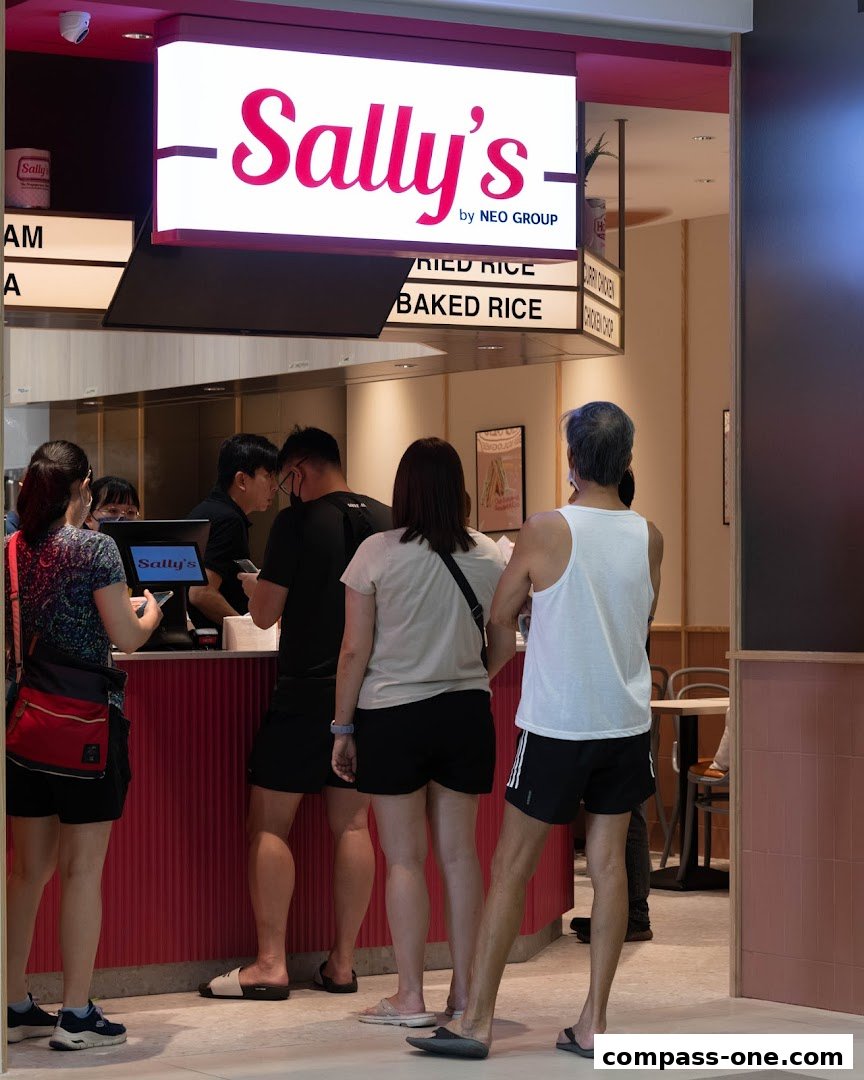 People queuing at Sally's by Neo Group, a food establishment with a prominent sign.