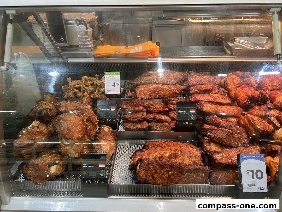 A display case filled with various roasted meats, including chicken, ribs, and pork knuckles.