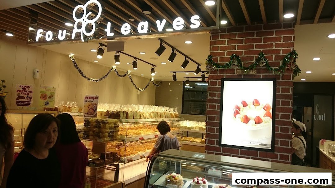 A bakery shop called Four Leaves with a display of baked goods and a cake advertisement.