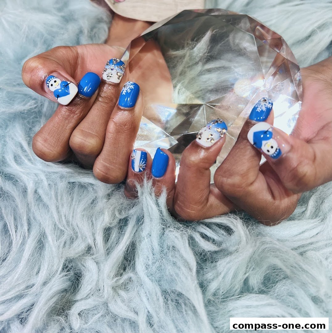 Close-up of hands with festive blue and white snowman and snowflake nail art.