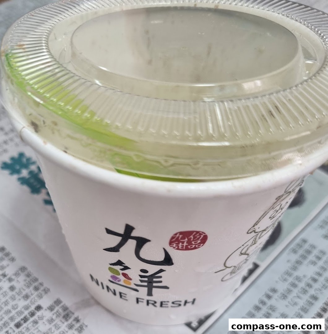 A white paper cup with a clear plastic lid, featuring the Nine Fresh Desserts logo.