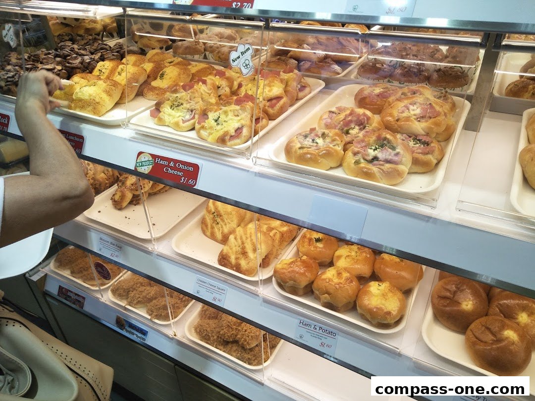 A display case filled with various baked goods, including pastries and bread, at the Four Leaves bakery.