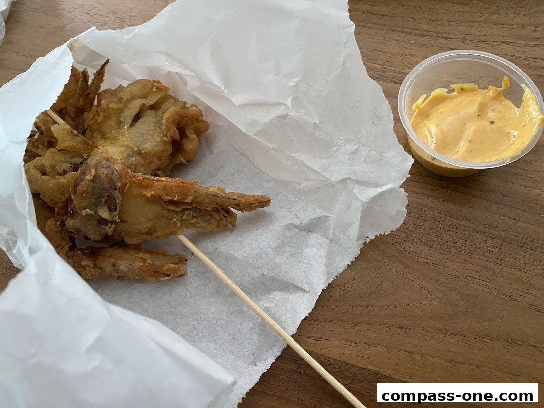 Crispy fried calamari on a skewer with a side of dipping sauce.