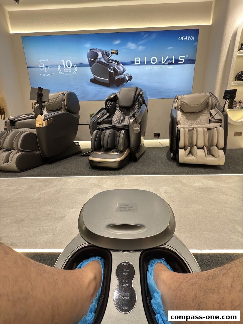 A person's feet in blue covers inside a foot massager, with massage chairs in the background.