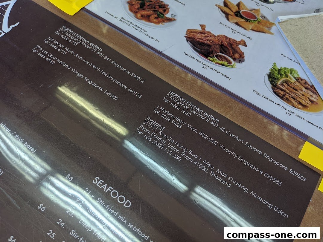 A close-up view of a Thai restaurant menu featuring various dishes and outlet information.
