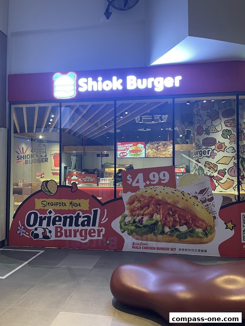 The exterior of Shiok Burger, a fast-food restaurant, showcasing its logo and a large advertisement for a Mala Chicken Burger Set.