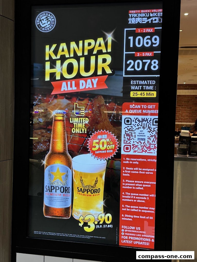 A digital display board for Yakiniku Like showing a 'Kanpai Hour' promotion with Sapporo beer.