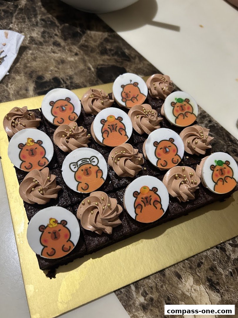 A chocolate brownie tray decorated with cute bear-themed edible toppers and chocolate frosting.