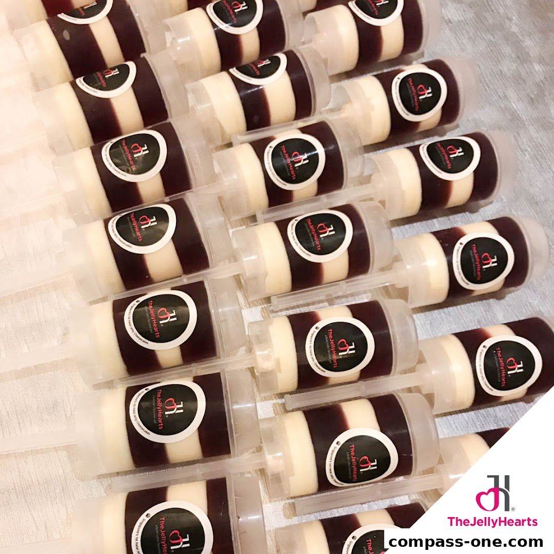 A collection of layered jelly desserts in clear push-up containers, branded with The JellyHearts logo.