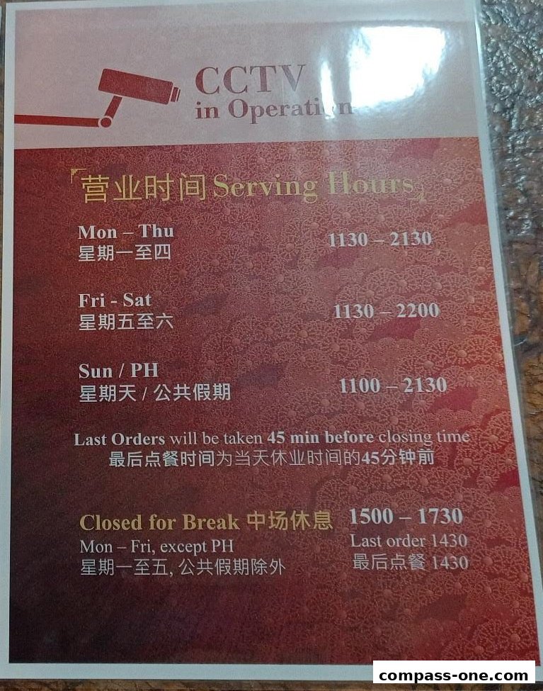 A sign displaying serving hours and CCTV information for Din Tai Fung.